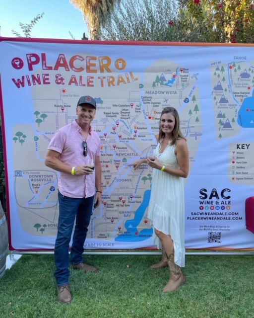 man and women, owners standing in front of large area map of wine trail.